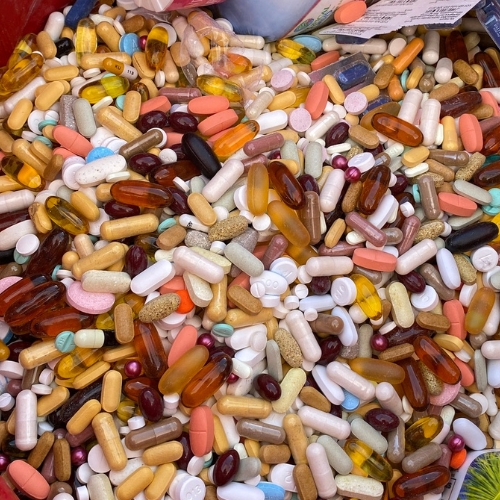Thousands of loose pills in various colors and medications in original packaging